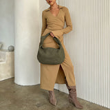 A model wearing a suede recycled vegan leather shoulder bag against a knot.