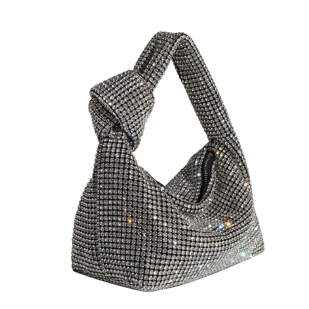 A small silver crystal encrusted top handle bag with a knot,