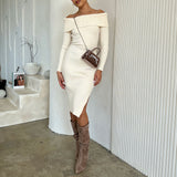 A model wearing a mini velvet top handle bag with a silver encrusted bow against a white wall. 