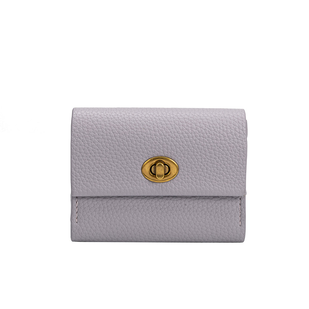 A small lilac pebble vegan leather card case wallet with a gold clasp. 