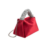 A medium velvet red top handle bag with a silver encrusted handle. 