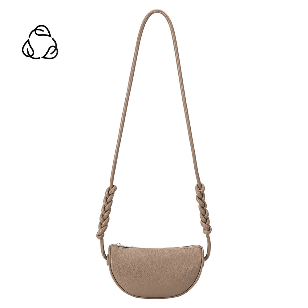 A small taupe crescent shaped vegan leather crossbody bag with a braided handle. 