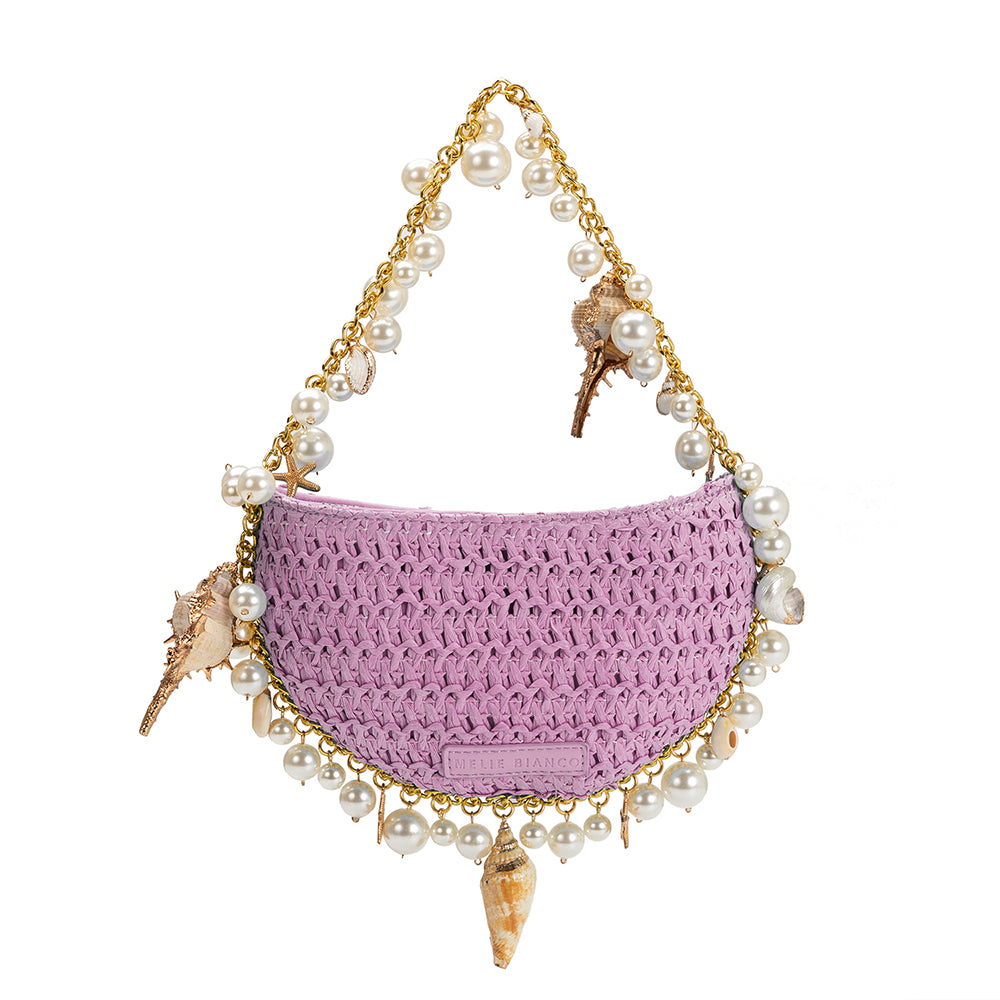 A small lavender crochet straw top handle bag with seashell detail along the handle.