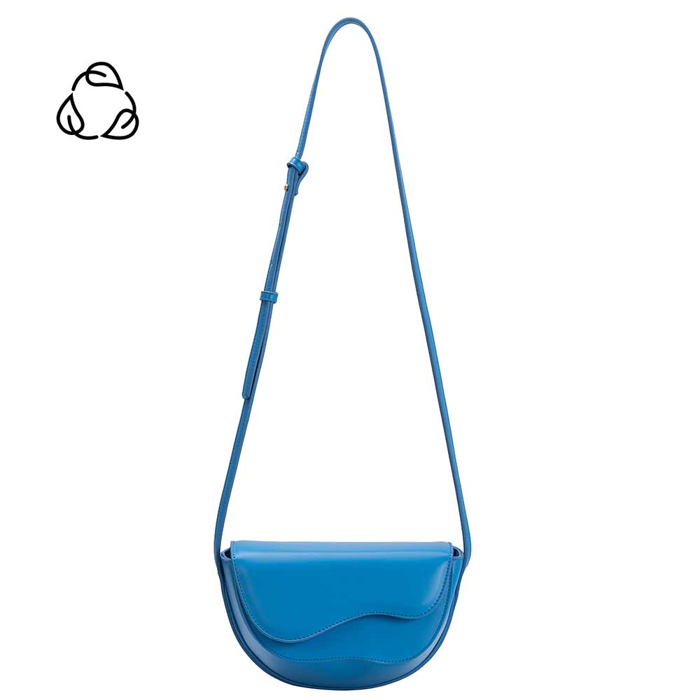 A small blue vegan leather crossbody bag with a wavy front flap closure.