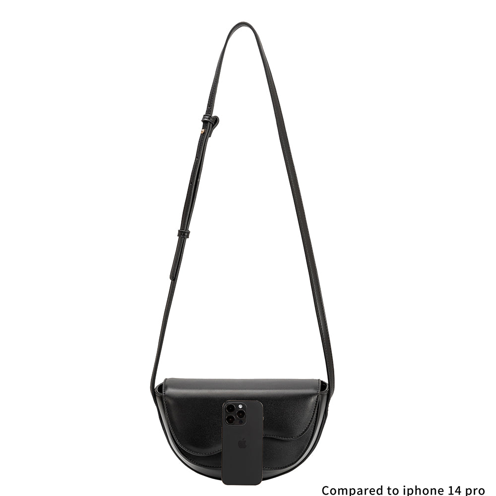 An iphone 14 size comparison image for a small vegan leather crossbody bag with a wavy front flap closure.