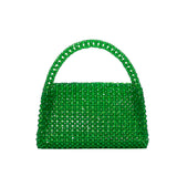 A small emerald crystal beaded top handle bag with a flap closure.