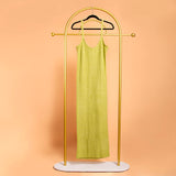 A still image of a green midi rib knit dress on a hanger with a orange background.