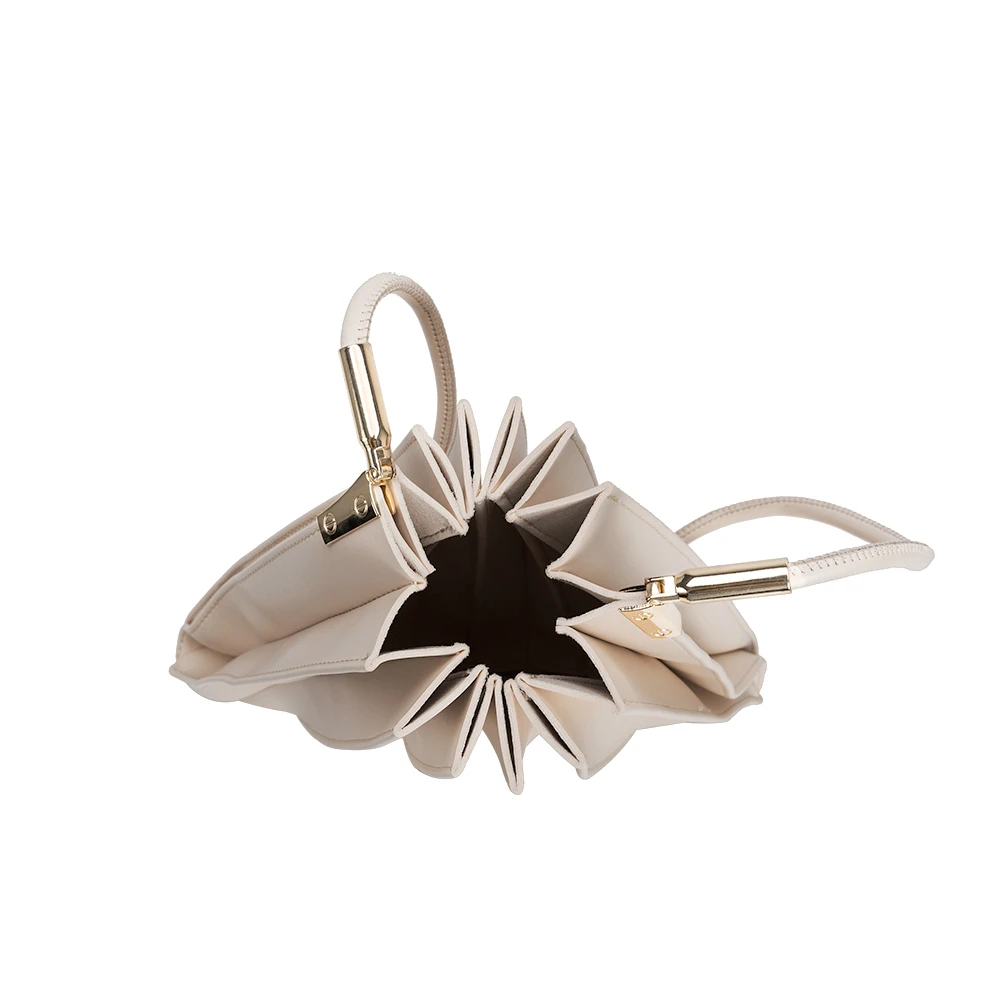 A bone pleated vegan leather shoulder bag with gold clasps.