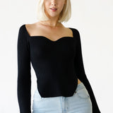 a model wearing a sweetheart neckline rib knit longsleeve top. 
