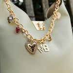Gold chain with charms on a light green handbag