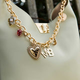 Gold chain with charms on a light green handbag
