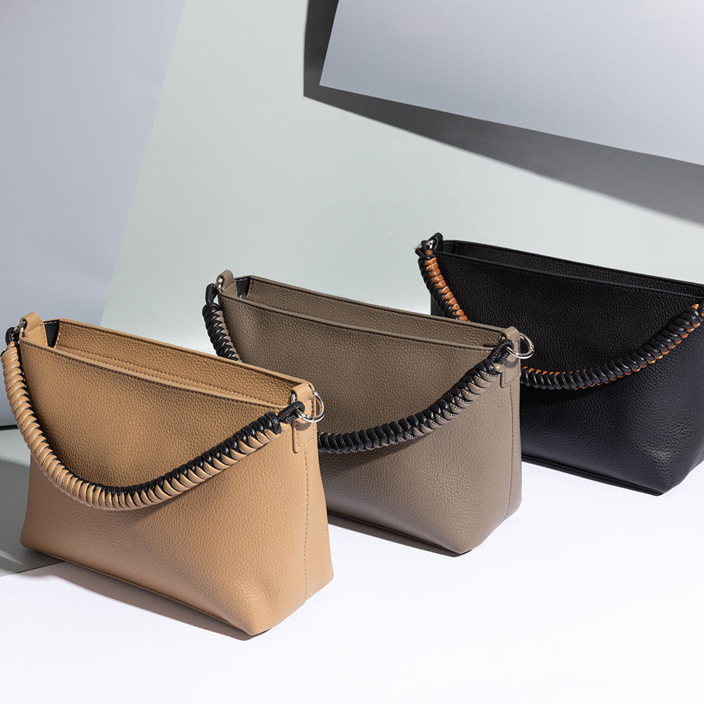 A still image of three small recycled vegan leather crossbody handbags against a grey background. 
