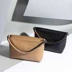 A still image with two small recycled vegan leather crossbody handbags against a grey background. 
