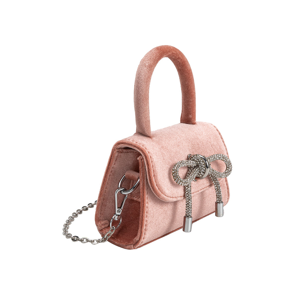 A mini blush velvet top handle bag with a silver encrusted bow.