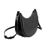 A black crescent vegan leather crossbody bag with silver hardware. 