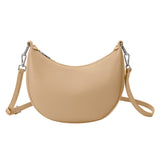 A nude crescent vegan leather crossbody bag with silver hardware. 