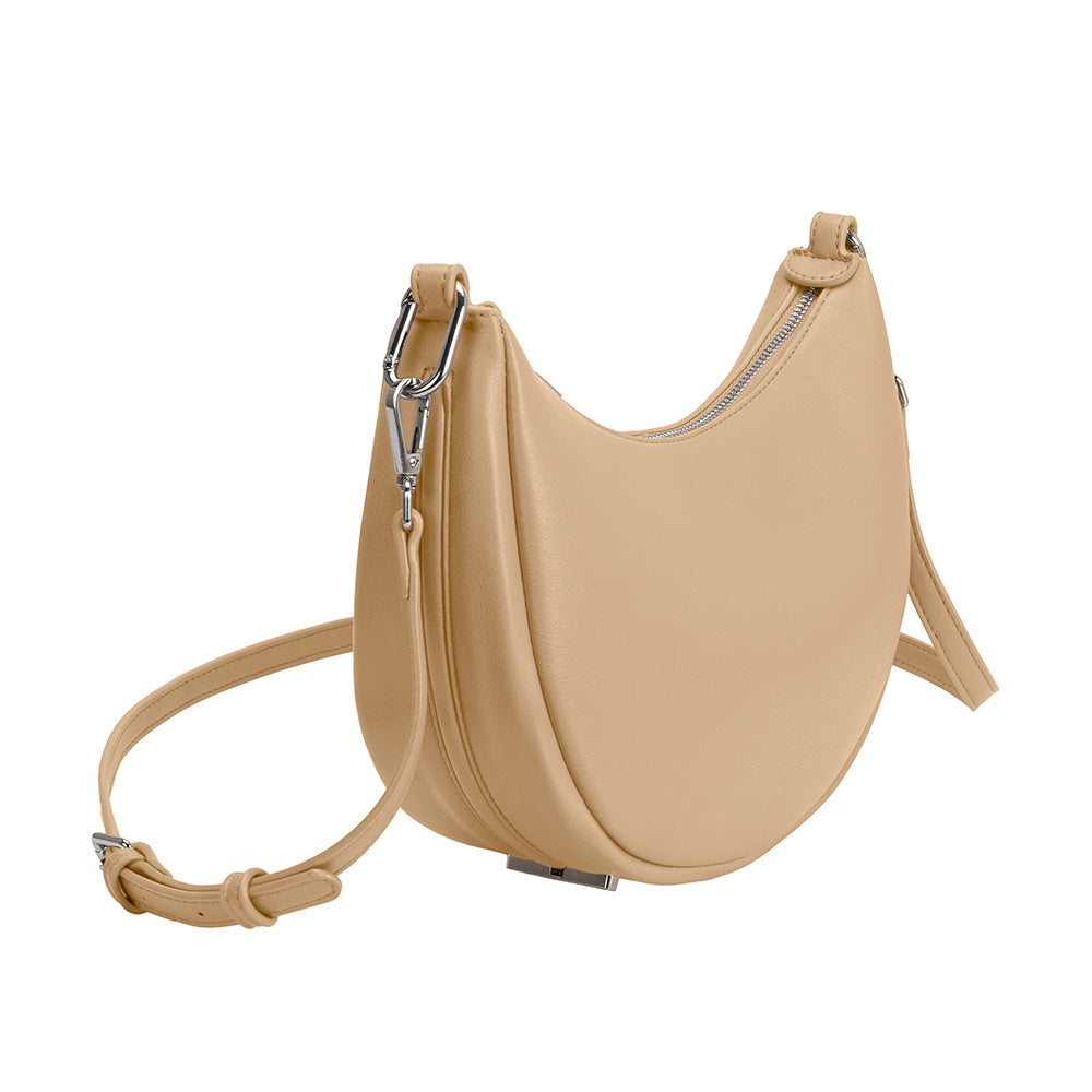 A nude crescent  vegan leather crossbody bag with silver hardware. 