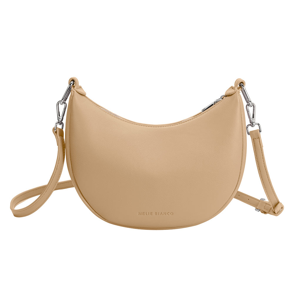 A nude crescent vegan leather crossbody bag with silver hardware. 