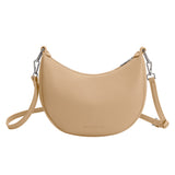 A nude crescent vegan leather crossbody bag with silver hardware. 