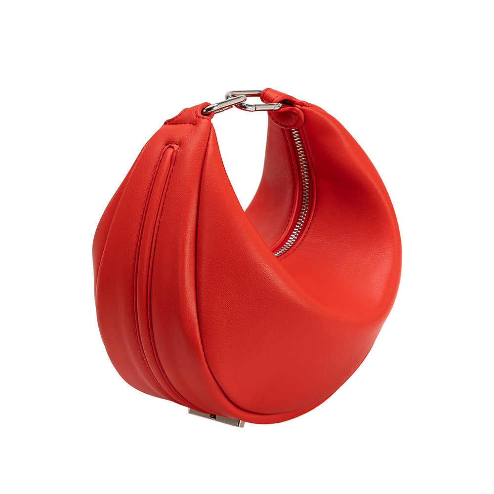 A red crescent vegan leather crossbody bag with silver hardware. 