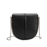 A black vegan leather crossbody handbag with silver handle.