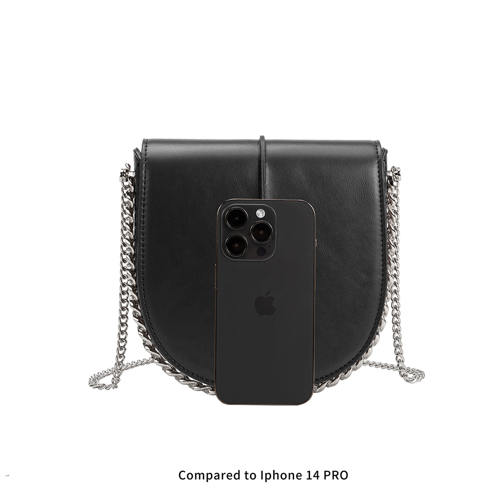 A black vegan leather crossbody handbag with Iphone 14 as size comparison.