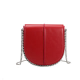 A red vegan leather crossbody handbag with silver handle.