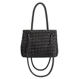 A black handwoven vegan leather crossbody bag with a curved handle. 