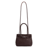 A espresso hand woven vegan leather crossbody bag with curved handle.