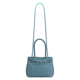 A sky hand woven vegan leather crossbody bag with a curved handle. 