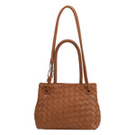 A tan hand woven vegan leather crossbody bag with a curved handle. 