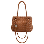 A tan hand woven vegan leather crossbody bag with a curved handle. 