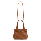A tan hand woven vegan leather crossbody bag with a curved handle.