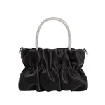 A mini black velvet vegan leather top handle bag with a silver encrusted handle. 