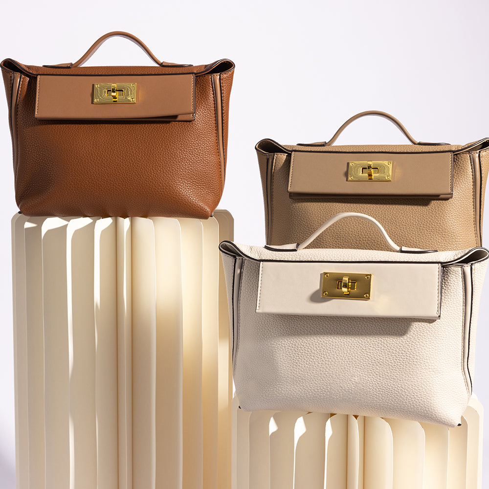 A still image of three medium vegan leather crossbody bag against a white wall on columns. 