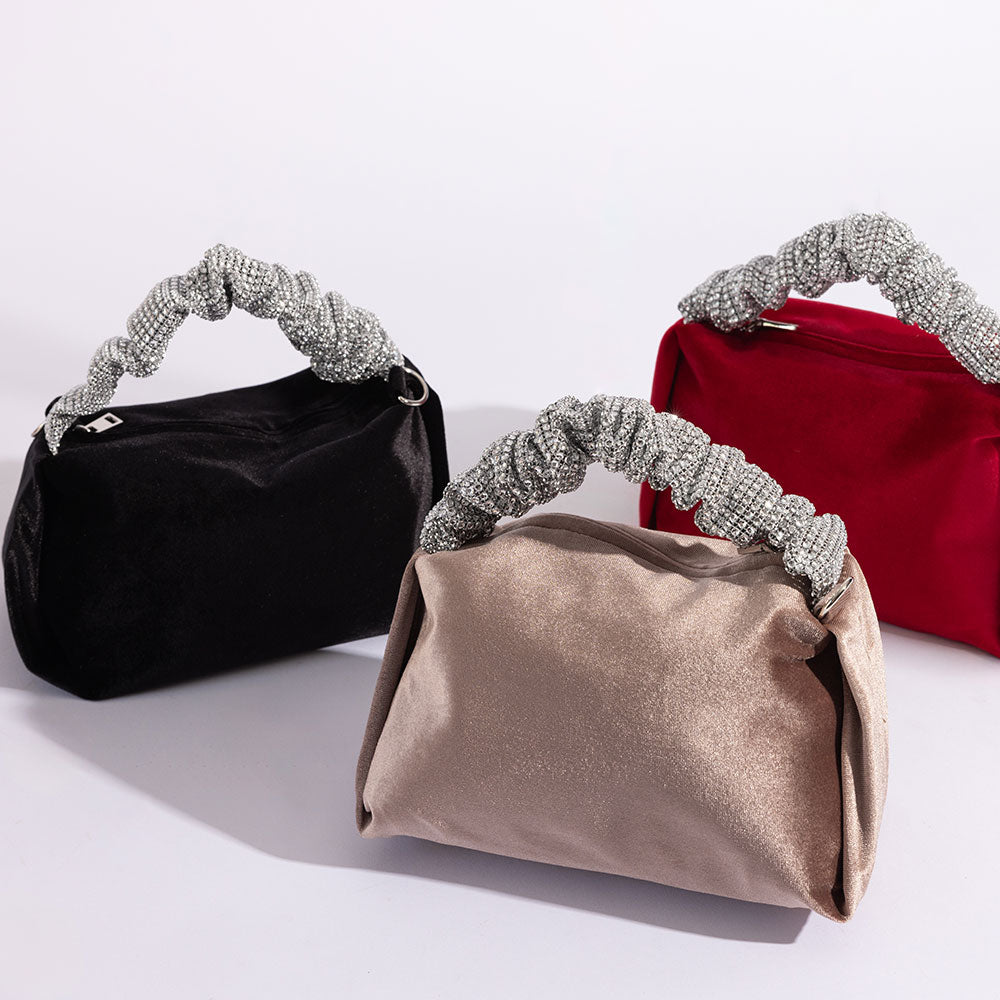 A still image of three velvet top handle bags with silver encrusted handle.