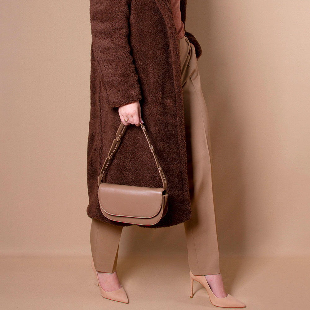 Model in a brown faux fur coat and turtle neck wearing a Melie Bianco  taupe crossbody bag.