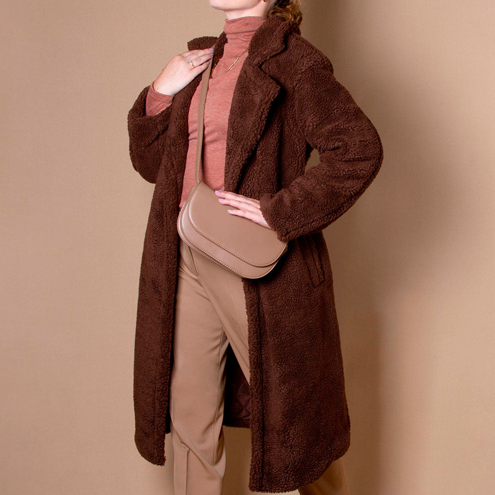 Model in a brown faux fur coat and turtle neck wearing a Melie Bianco  taupe crossbody bag.