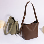 A still image of two recycled vegan leather shoulder bag with adjustable strap against a white background. 