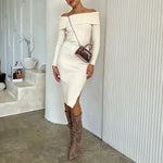 A model wearing a mini velvet top handle bag with a silver encrusted bow against a white wall.