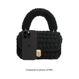A black knitted handbag with an Iphone 14 for size comparison. 