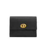 A small black pebble vegan leather card case wallet with a gold clasp.