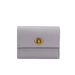 A small lilac pebble vegan leather card case wallet with a gold clasp. 