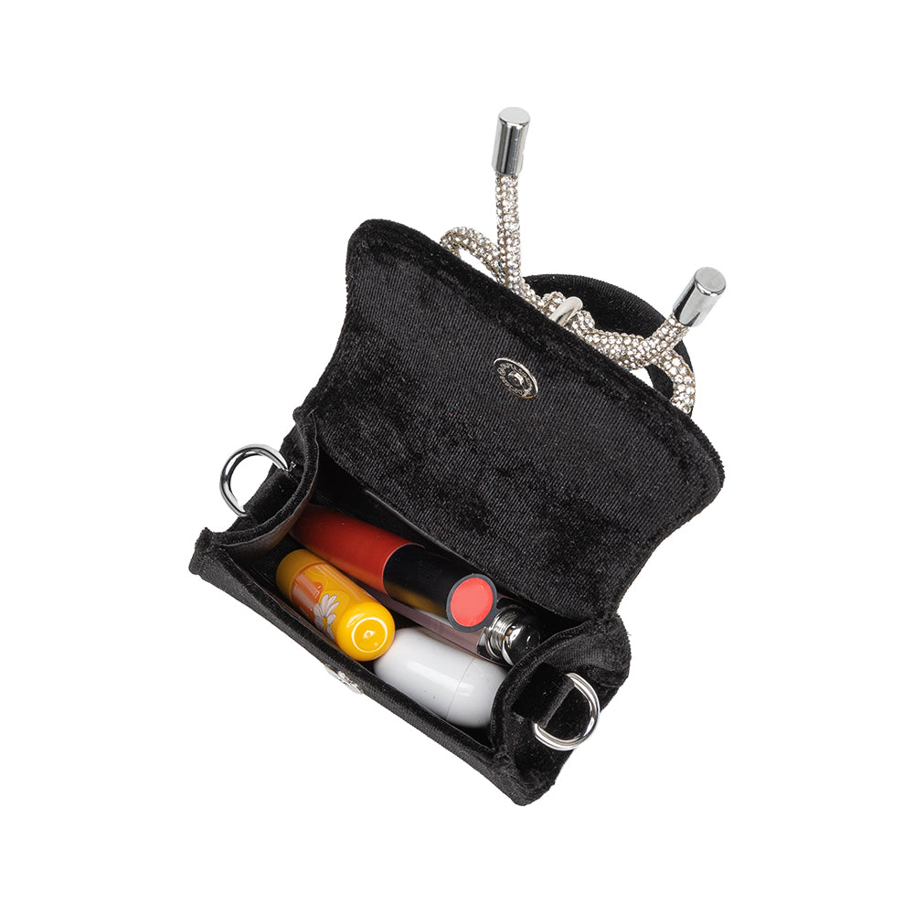 An inside view image of a mini black velvet top handle bag with earbuds and lipgloss inside. 