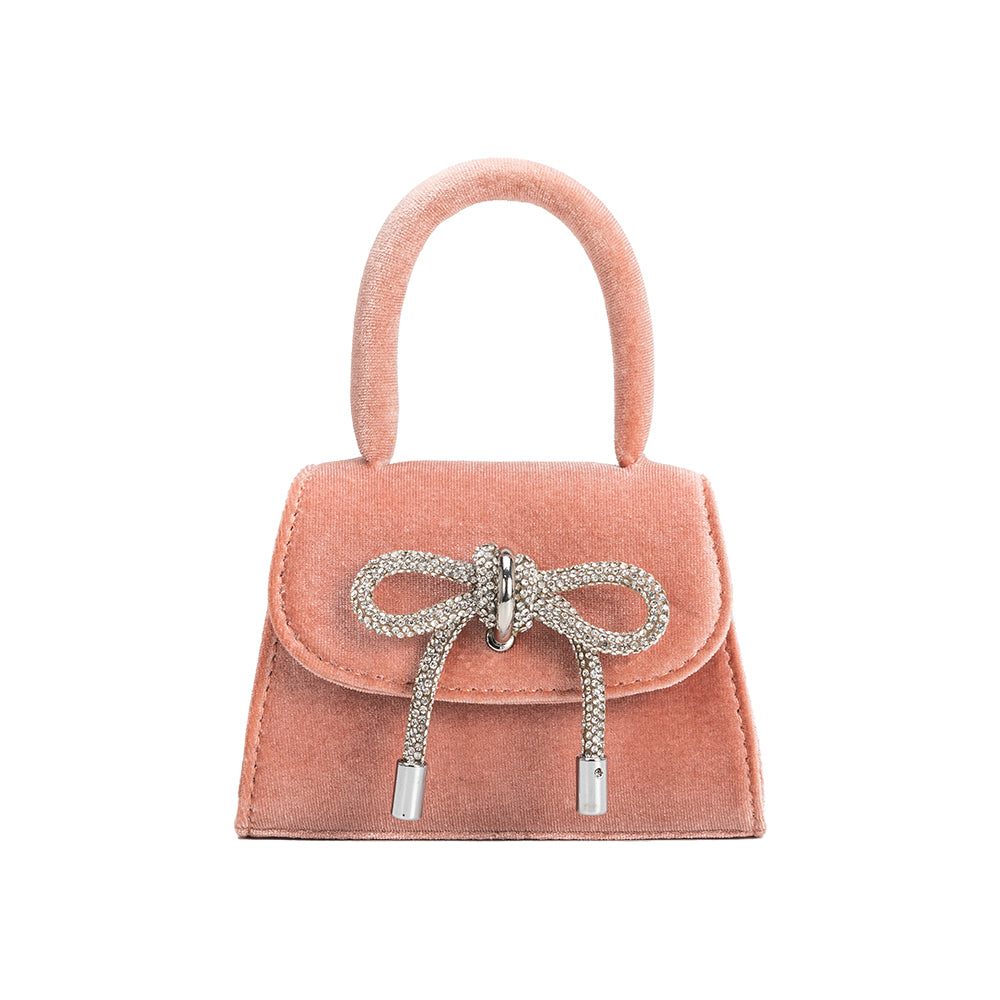 A mini blush velvet top handle bag with a silver encrusted bow.