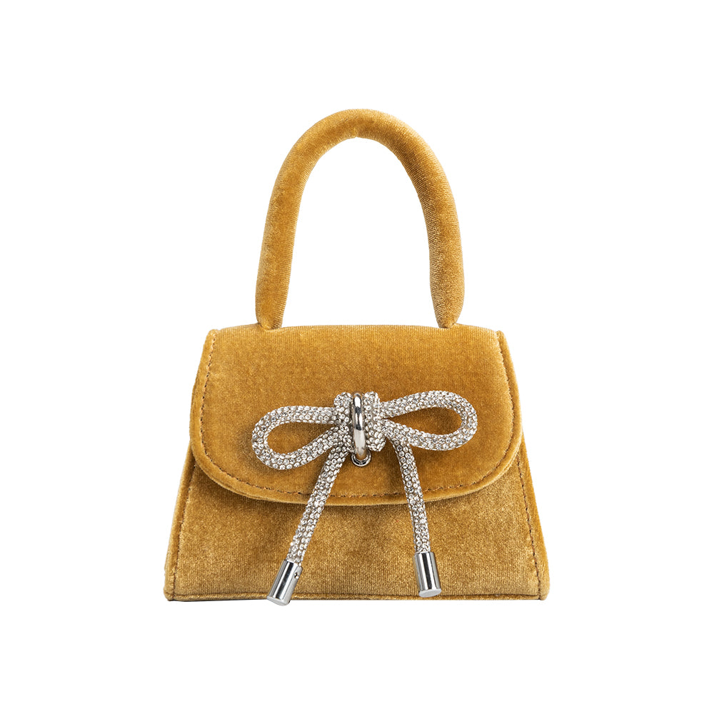 A mini gold velvet top handle bag with a silver encrusted bow.