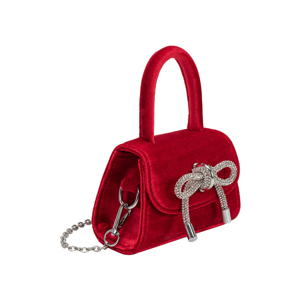 A mini red velvet top handle bag with silver encrusted bow.