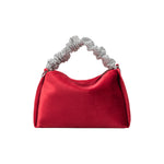 A medium red velvet top handle bag with a silver encrusted handle. 