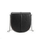 A black vegan leather crossbody handbag with silver handle.