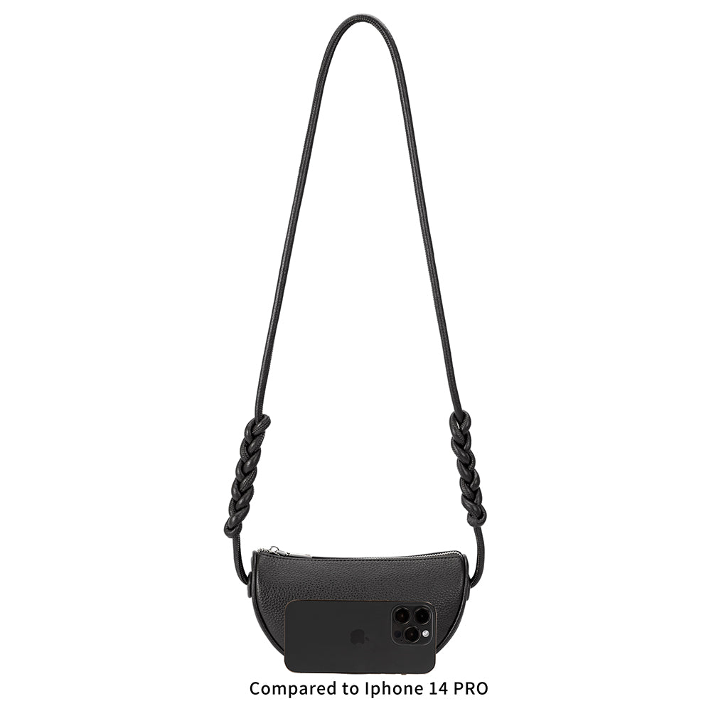 An iphone 14 pro size comparison image for a small crescent shaped vegan leather crossbody bag.